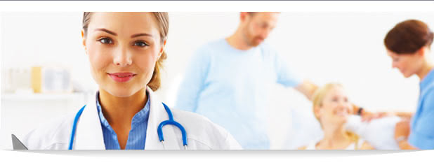 Female Doctor smiling with staff and patients in the background
